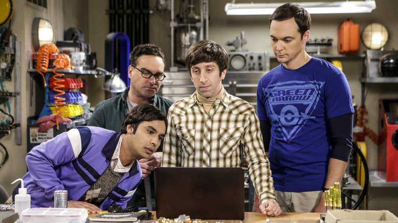 Raj, Leonard, Howard, and Sheldon looking at laptop in lab on The Big Bang Theory