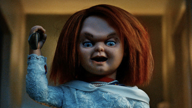 Chucky wearing a wedding dress while holding a knife