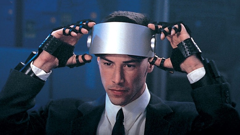 Johnny lowering a cyber visor over his eyes in Johnny Mnemonic (1995)