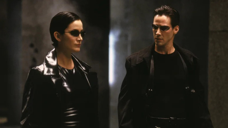 Neo and Trinity preparing for action in full leather and sunglasses in The Matrix (1999)