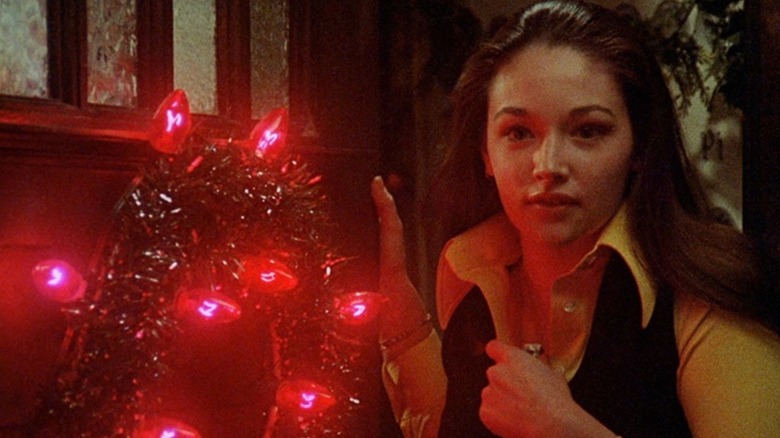 Jess Bradford stands next to a Christmas wreath in "Black Christmas" (1974)