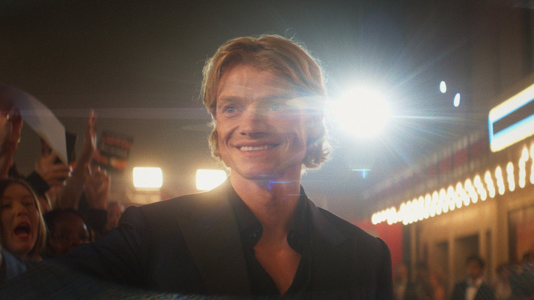 Matt Hagen smiling on a red carpet, backlit by a glimmering light, in Clayface (2026)