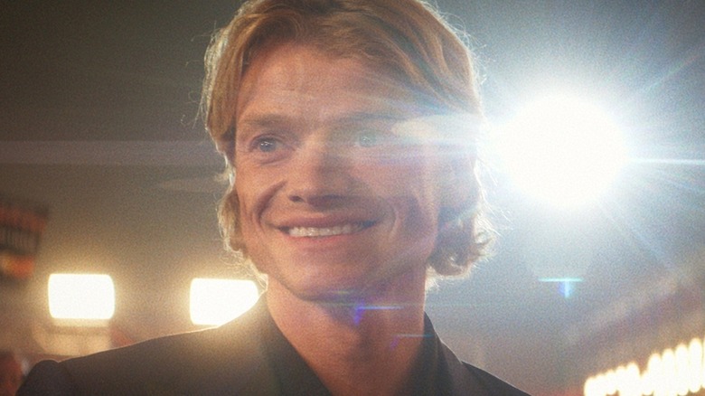 Matt Hagen smiling on a red carpet, backlit by a glimmering light, in Clayface (2026)