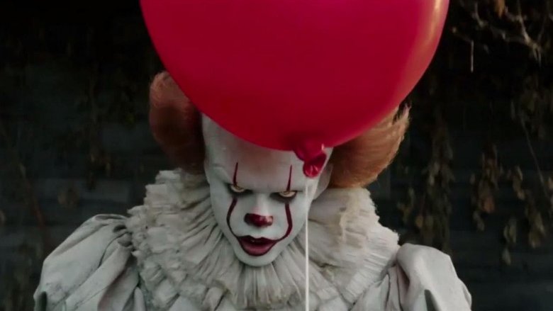 Pennywise the clown holding a red balloon in 