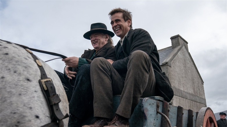 Colin Farrell and Brendan Gleeson laughing together in a carriage