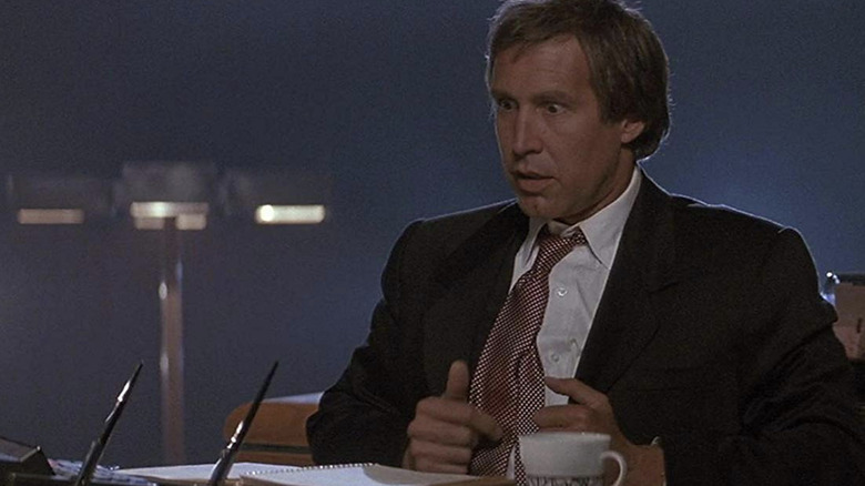 Nick sitting at a desk looking unsettled in Memoirs of an Invisible Man (1992)