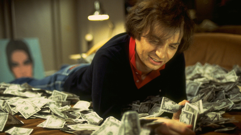 Mike Myers as Steve Rubell counting money on bed in 54 (1998)