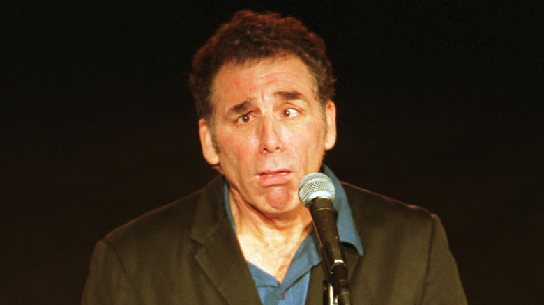 Michael Richards making a silly face in front of a microphone