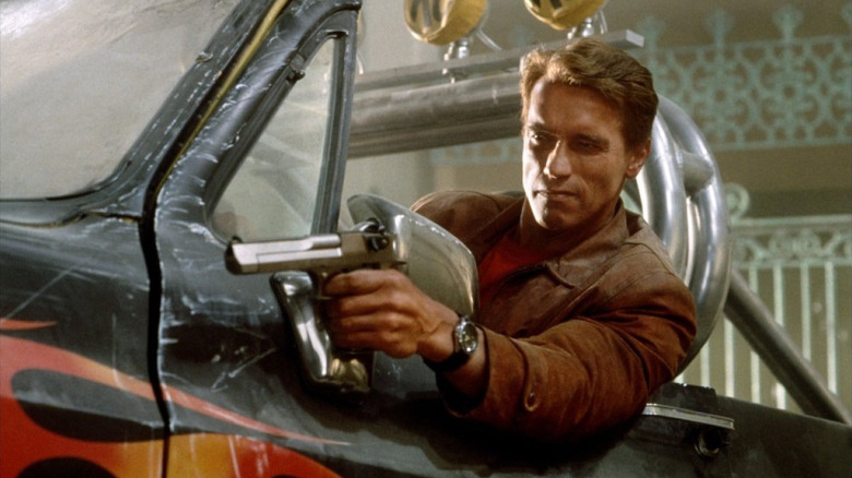 Detective Jack Slater aiming a gun from a monster truck in Last Action Hero