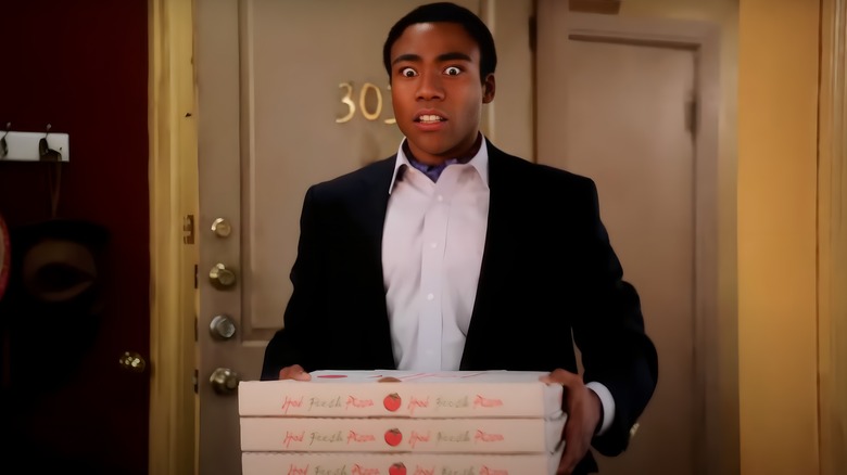 Troy Barnes holding pizza boxes