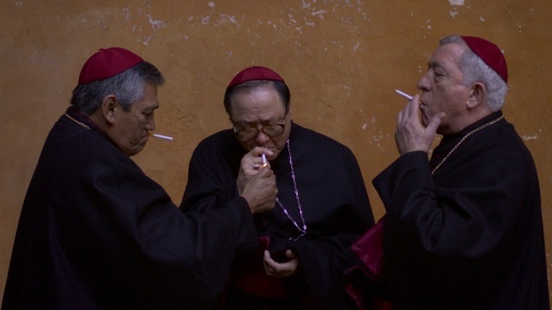 Three cardinals smoking outdoors