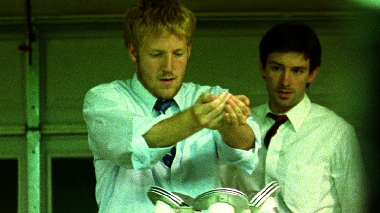 Adam watching Aaron put hands over machine in Primer (2004)