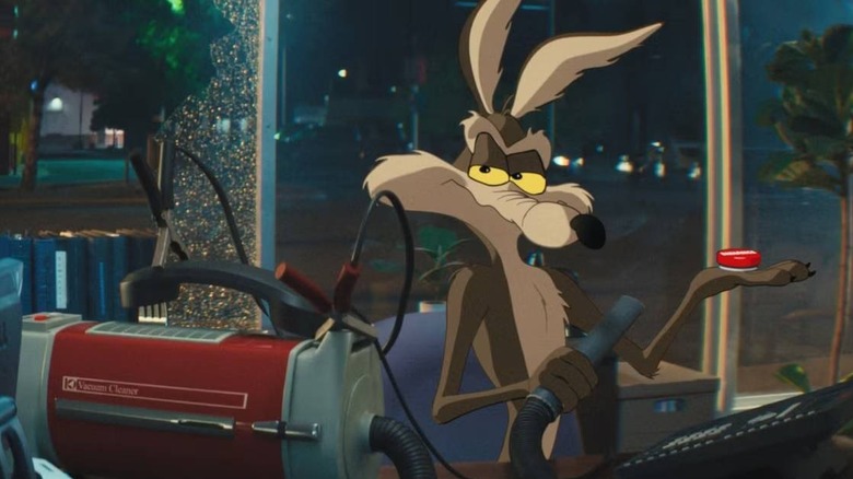 Wile E. Coyote holding a vacuum and a button in Coyote vs. Acme