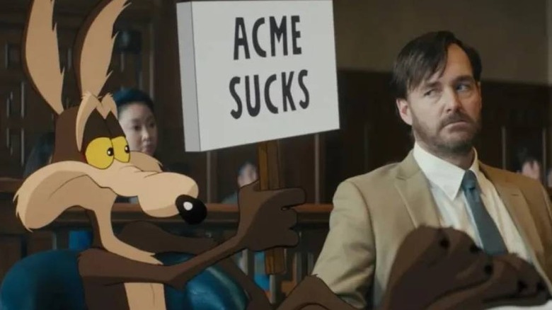 Wile E. Coyote holding a sign that reads "Acme Sucks" in Coyote vs. Acme