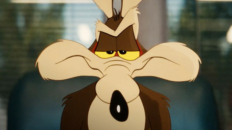 Wile E. Coyote sits in a chair smirking in 