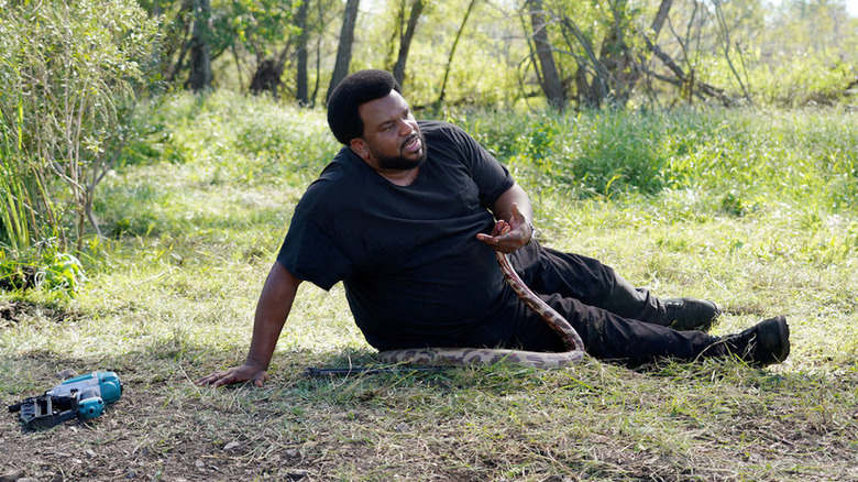 Craig Robinson holding a snake in Killing It