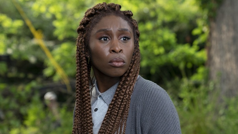 Holly stands amidst trees in "The Outsider" (2020)