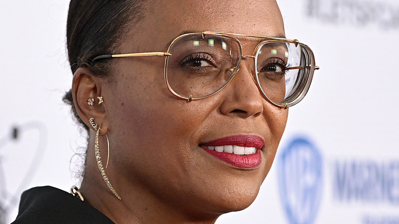 Aisha Tyler wearing glasses and smiling at event