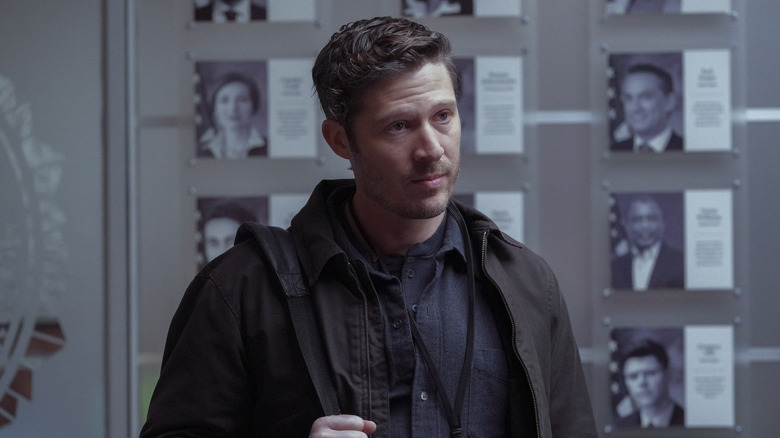 Zach Gilford as Voit looking thoughtful
