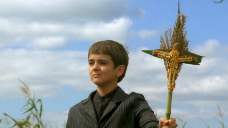 Isaac holds up corn crucifix
