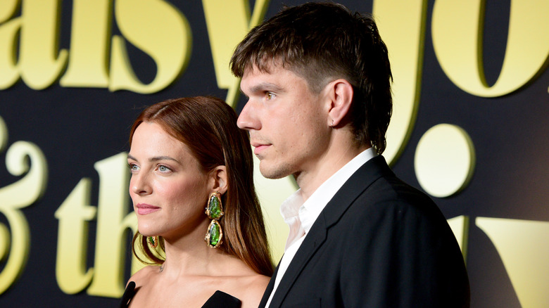 Riley Keough and Ben Smith-Petersen posing together on red carpet