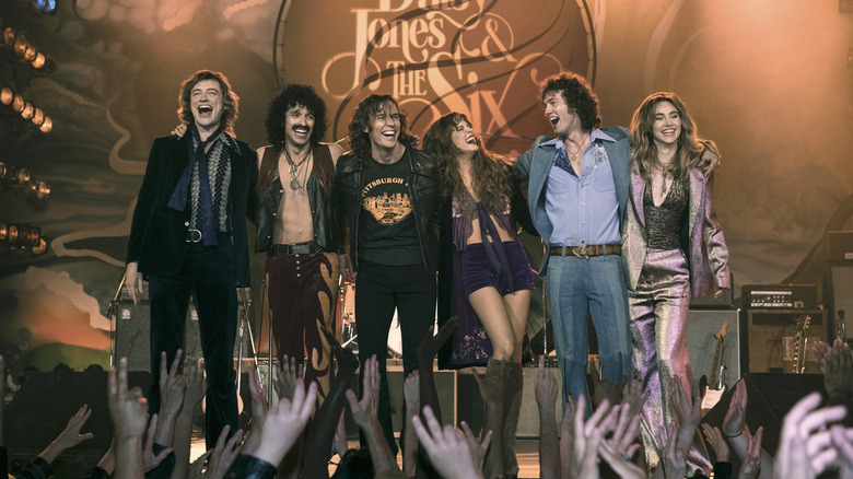 Daisy Jones & The Six smile on stage 