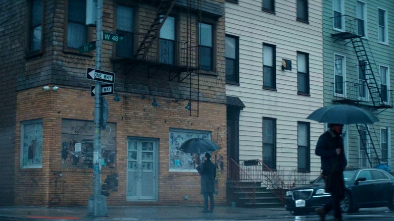 Matt Murdock looking up at a New York building in the rain