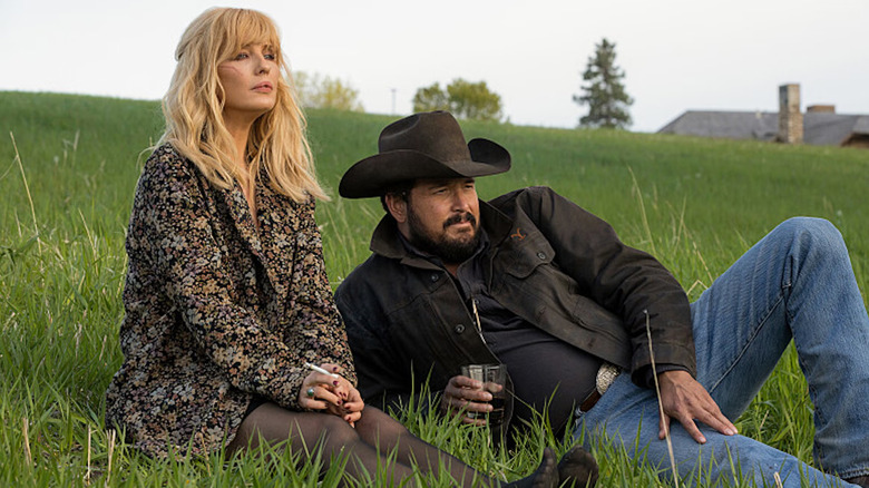 Rip and Beth sit in a field in "Yellowstone"