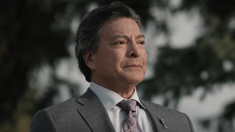 Thomas Rainwater wearing a suit and listening in "Yellowstone"
