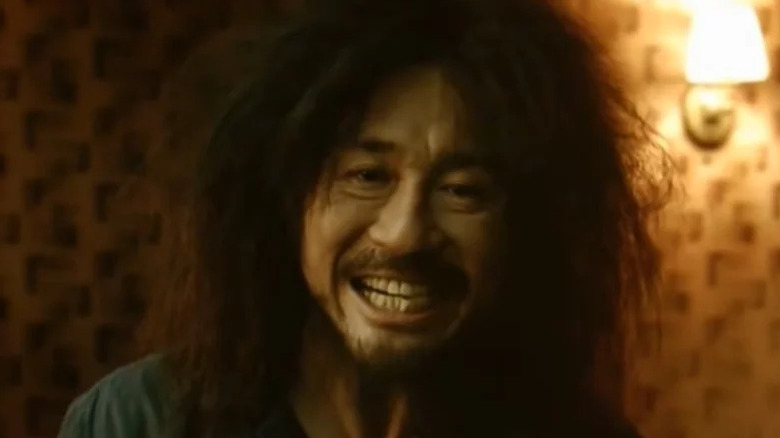 Oh Dae-su grinning desperately in Oldboy