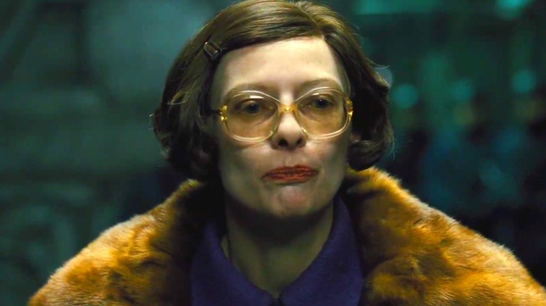 Minister Mason wearing thick glasses and a fur coat in Snowpiercer