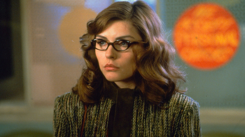 Nicki Brand wearing glasses and a blazer in 