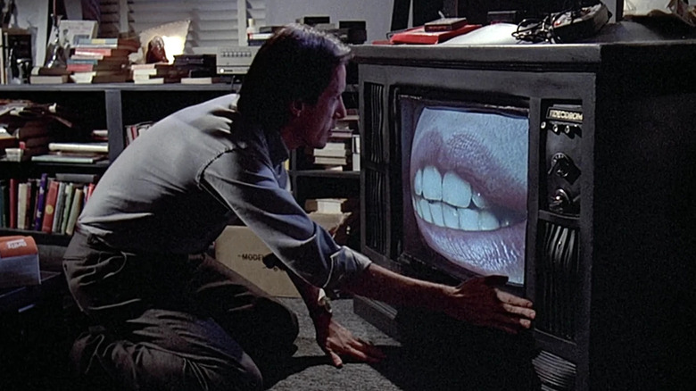 Max Renn gets sucked into a TV in "Videodrome" (1983)