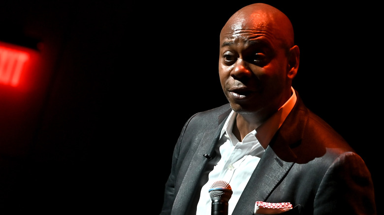 Dave Chappelle holding a microphone