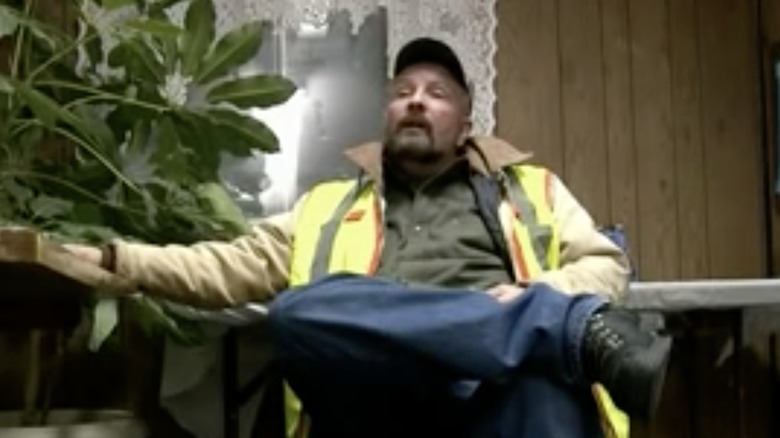 Dave Redmon sitting cross-legged in a chair