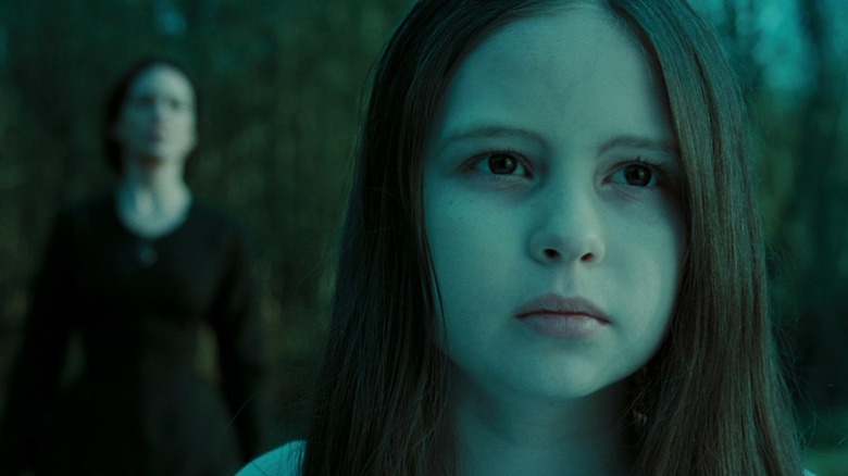 Samara looking into the distance with her mother behind her in The Ring