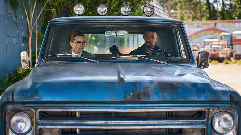 Jamie Foxx and Dave Franco sitting in a car in Day Shift