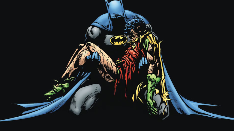 Batman, steeped in black, cradling the beaten, worn body of Jason Todd aka Robin