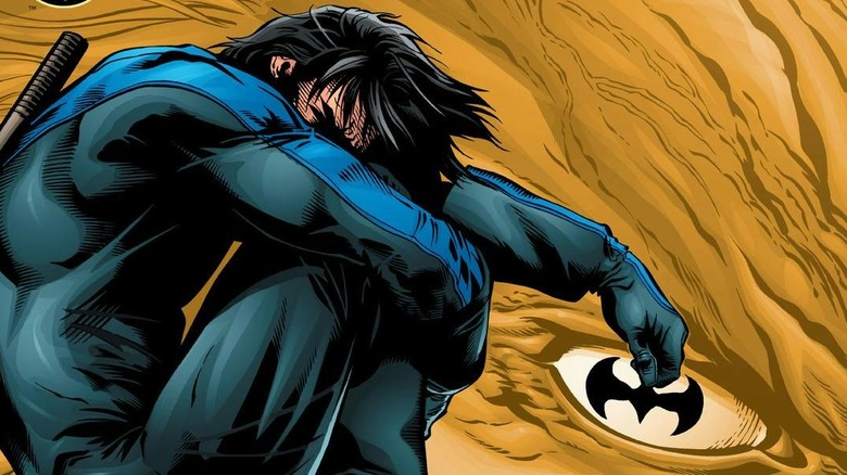 An image of Nightwing curled into a ball and holding a batarang artfully, from the cover of issue #93