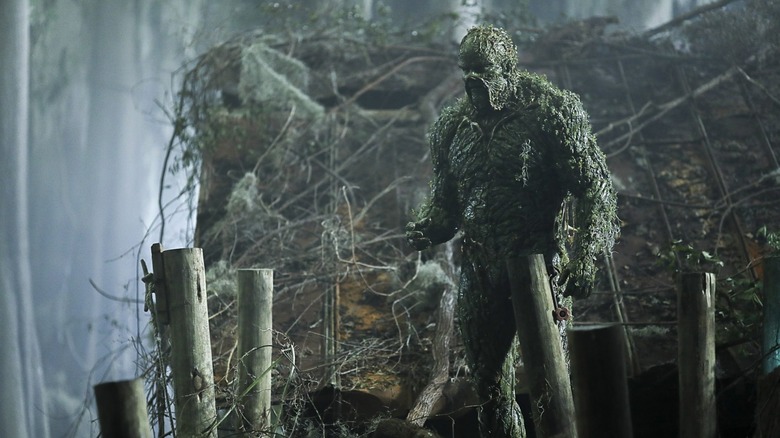 Swamp Thing stands on a pier in "Swamp Thing" (2019)