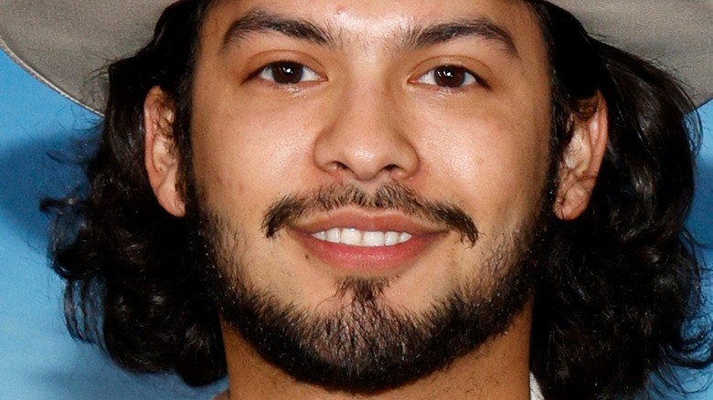 Xolo Maridueña at event with hat on smiling