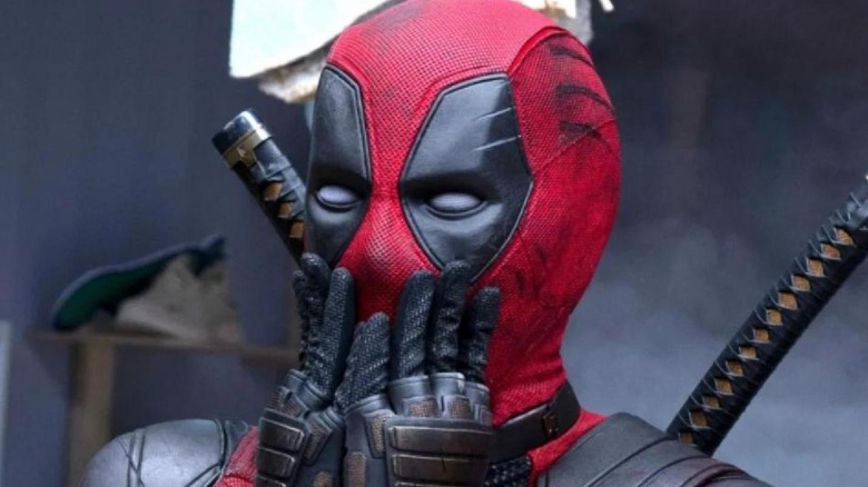 Deadpool holds his hands up to his mask in shock
