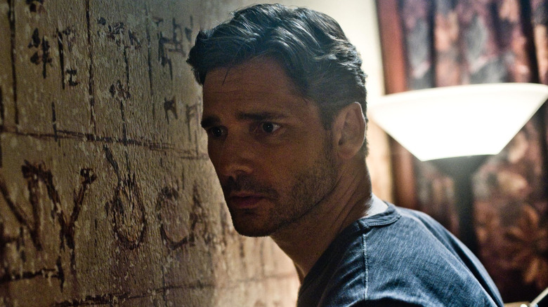 Ralph Sarchie looking at wall carvings in Deliver Us from Evil (2014)