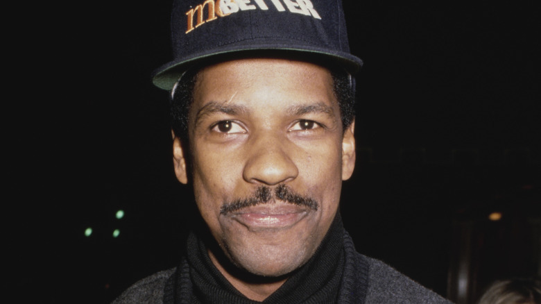Denzel Washington smiling with a 'Mo' Better Blues' baseball cap on (1990)
