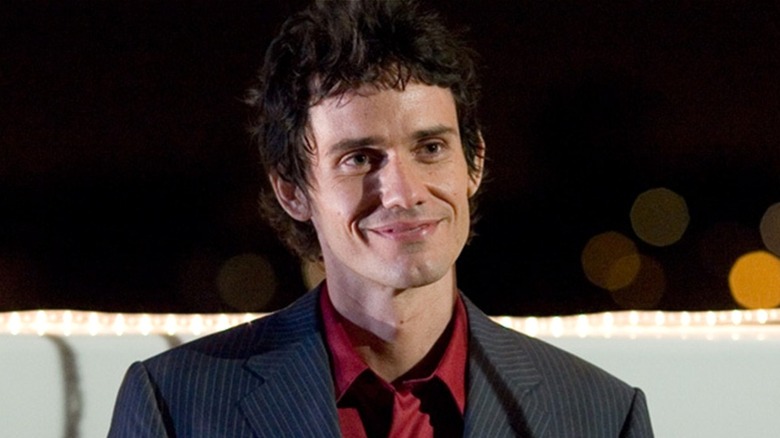 Brian Moser smiles menacingly at someone in 