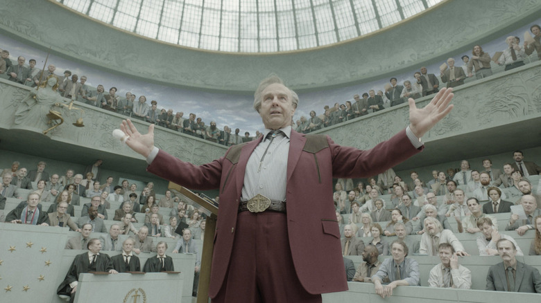 Digger outstretching his arms before an angry court in "Digger" (2026)