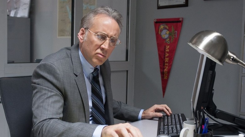 Evan Luke at his desk in "Dying of the Light" (2014)