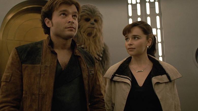Kira looking up at Han Solo as Chewbacca stands in the background in Solo: A Star Wars Story