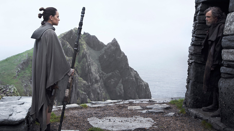 Rey approaching Luke Skywalker in his cave in Star Wars: The Last Jedi (2017)