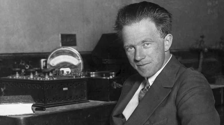 Werner Heisenberg sits at a desk